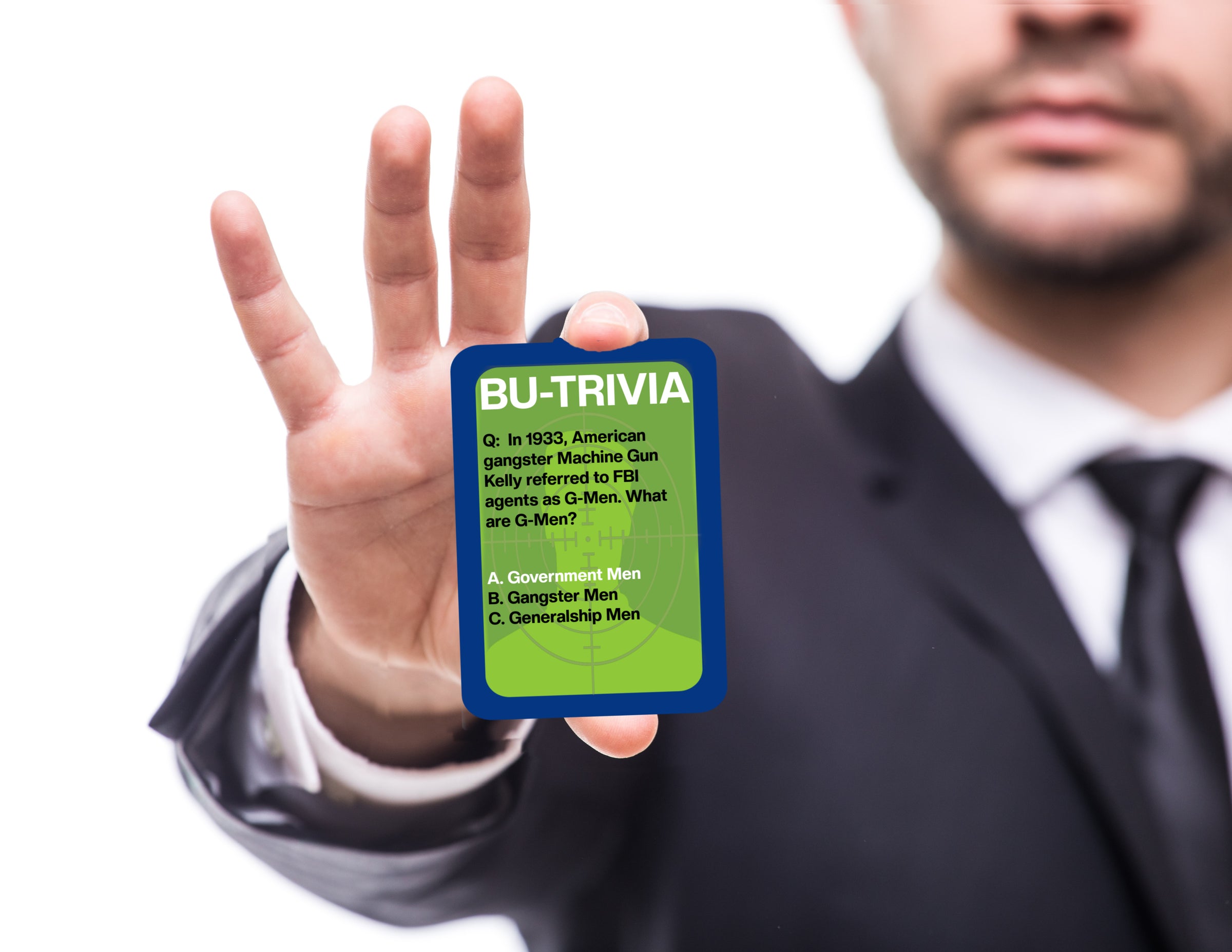 Man holding a card with trivia question and answer, wearing a suit.